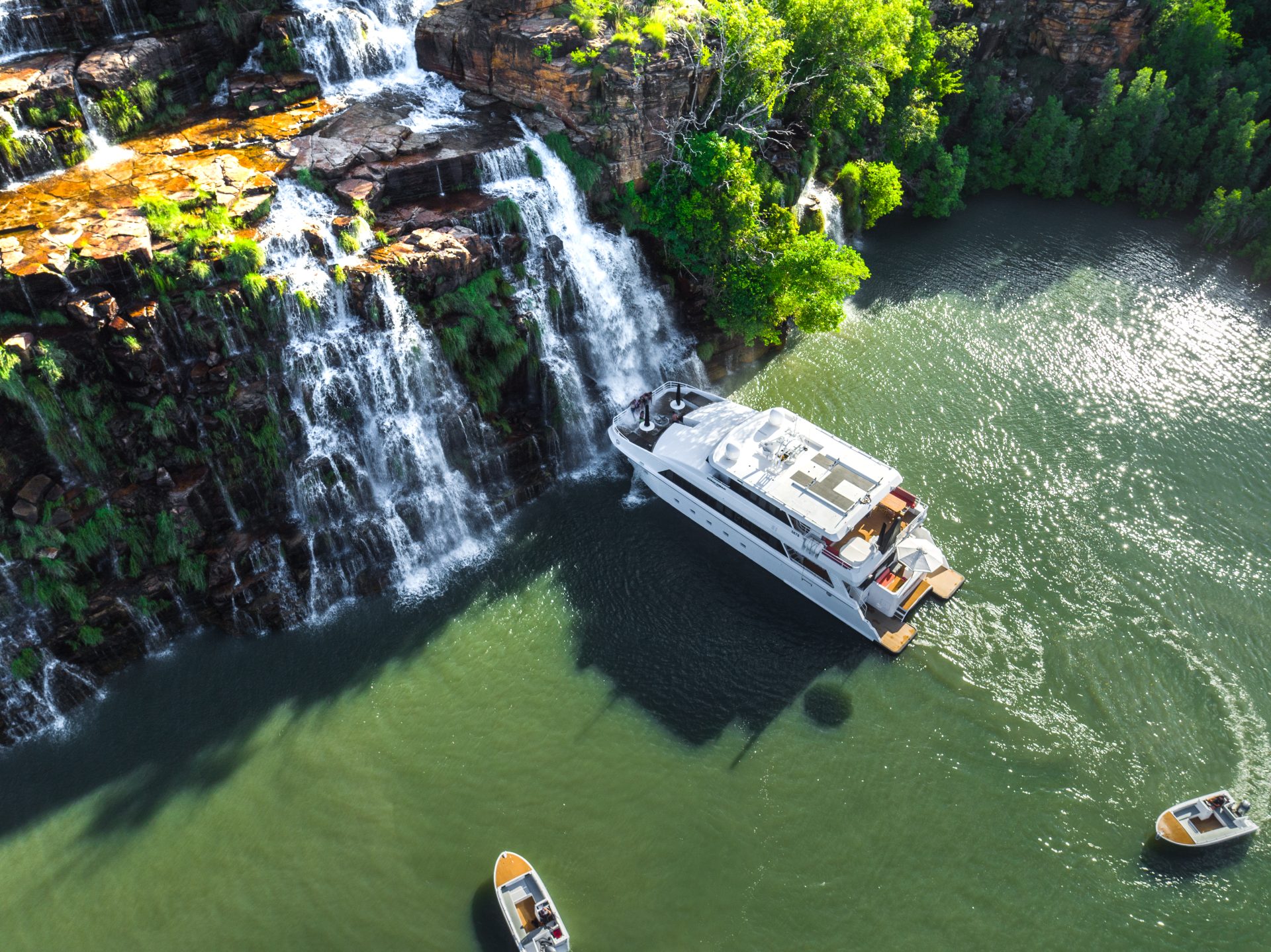 Superyacht moored at foot of waterfall