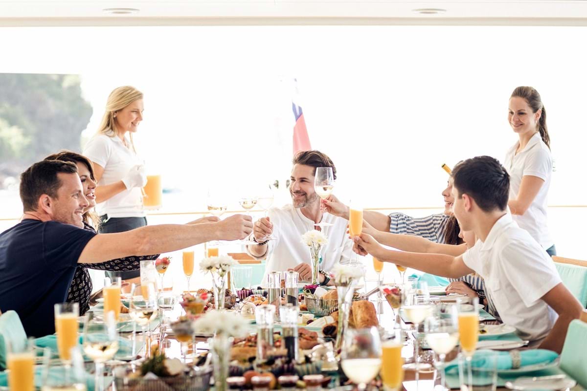 Guests onboard superyacht charter enjoying drinks and food